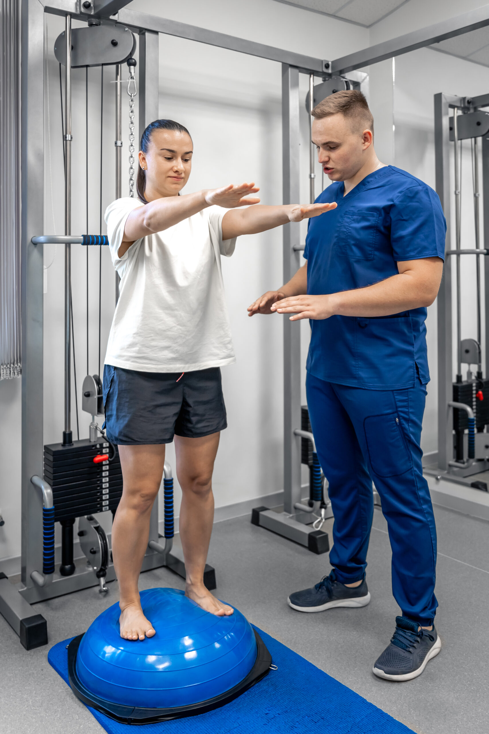 Balance exercise with bosu ball, woman and doctor in gym.